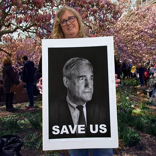 Woman holding picture of Robert Mueller. Text at bottom: "Save Us"